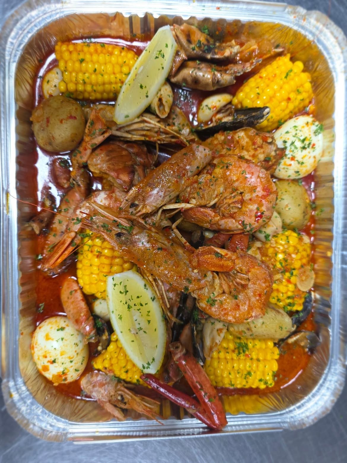 Ghost seafood tray with prawns, mussels, corn, potatoes and lemon